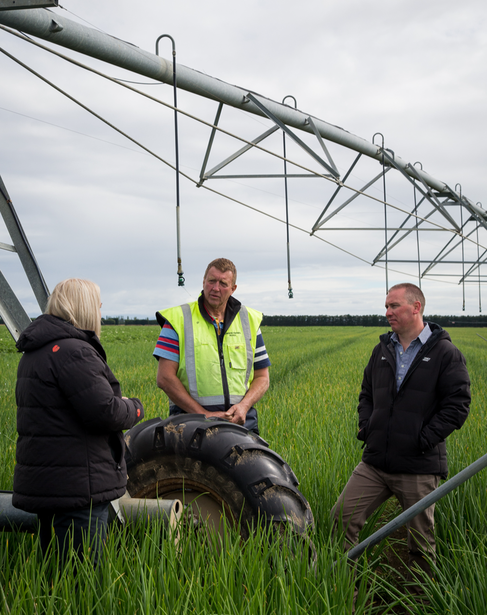 Irrigator in field with people talking